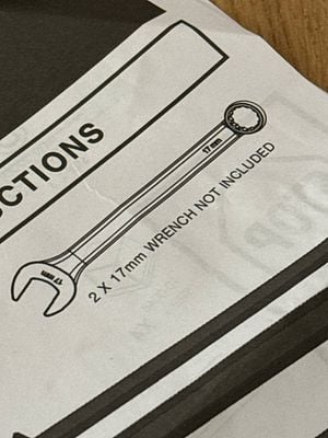 The image displays an instruction sheet featuring a wrench illustration.