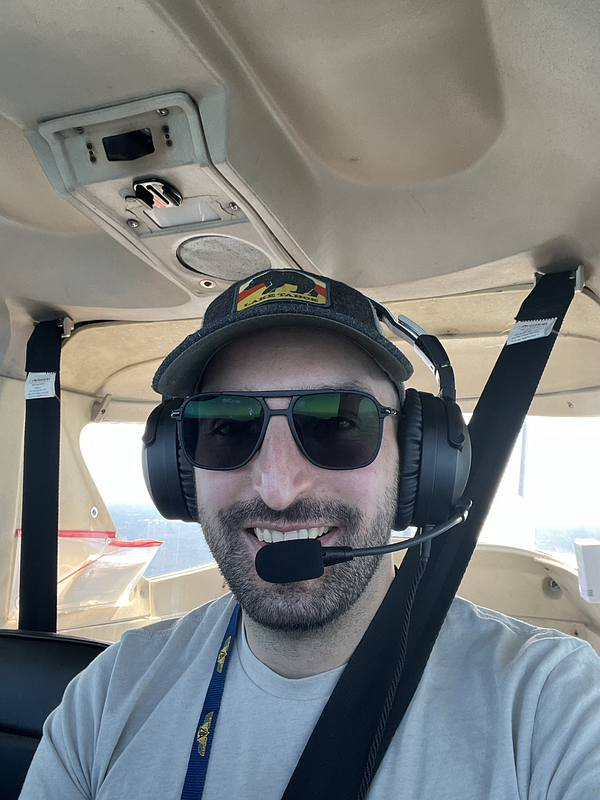Cockpit view of a Cessna 152 airplane showing flight instruments and controls during a daytime flight.