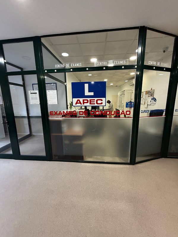 The image depicts the entrance of a driving exam center in Portugal.