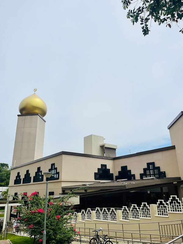 A mosque with a prominent golden dome and modern architectural features.