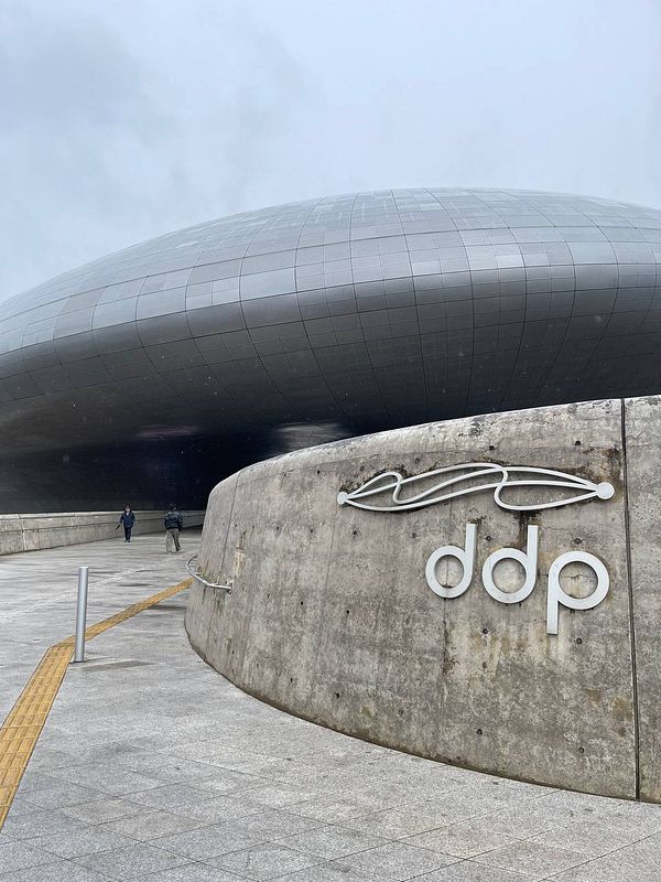 The image captures the Dongdaemun Design Plaza (DDP) in Seoul, South Korea, showcasing its futuristic architecture.