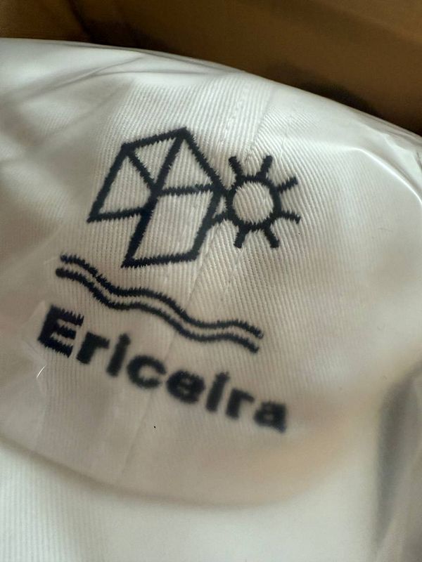 A close-up view of a white hat featuring a logo related to Ericeira.
