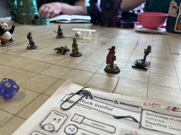 Illustration of a fantasy female character with long hair and a glowing tattoo on her arm against a dark background.