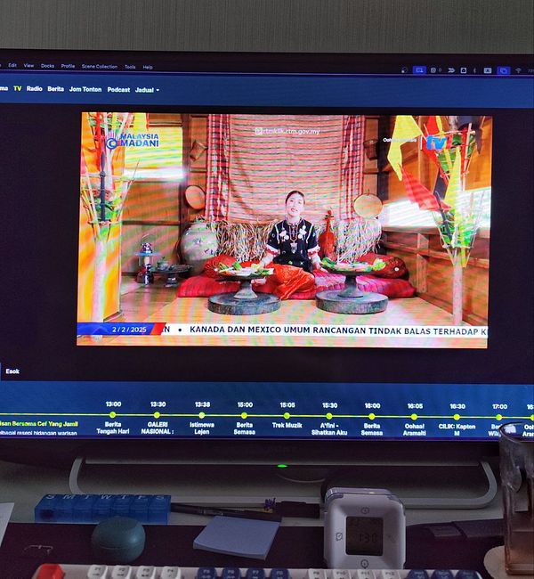 A woman is hosting a documentary segment on national TV, showcasing her ethnic culture in Sarawak, Malaysia.