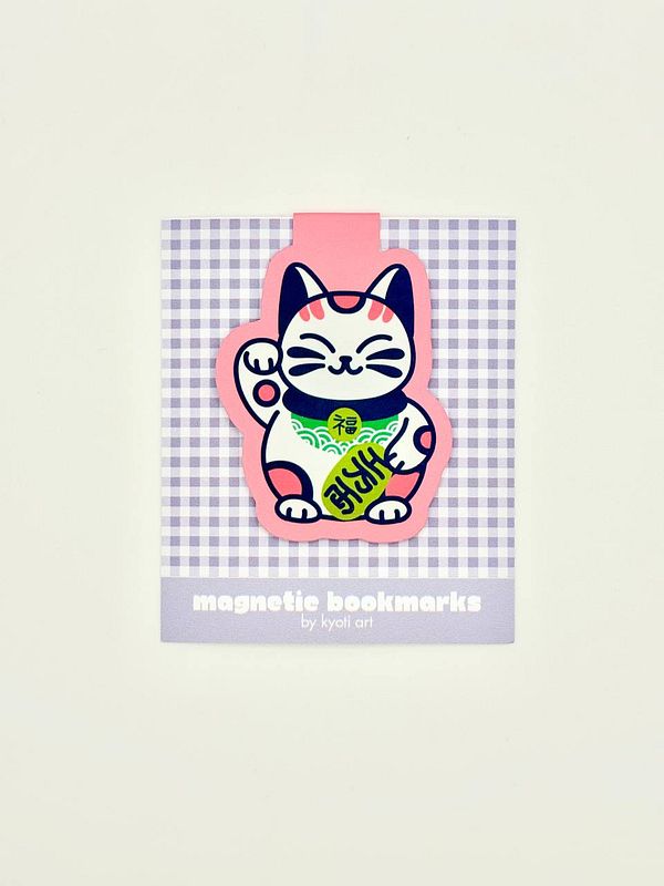 A colorful magnetic bookmark featuring a cat design is displayed on a checkered background.