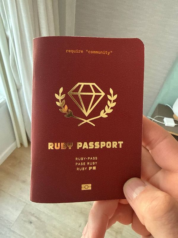 A wooden rubber stamp featuring the Ruby on Waves logo and branding is displayed on a wooden surface next to its packaging and a stamped impression on paper.