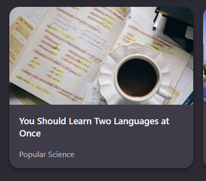 An overhead view of a coffee cup on a table with language learning materials.