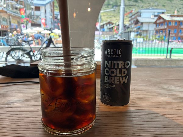 Close-up of a cup of specialty coffee on a rustic wooden surface.
