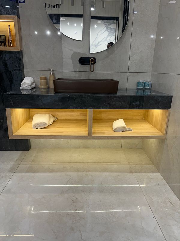 A modern bathroom vanity featuring a sleek design with a round mirror and stylish storage.