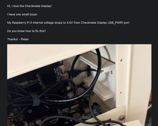 Text message describing a voltage issue with a Raspberry Pi 5 connected to a Checkmate Display, accompanied by a photo of the computer's internal components.