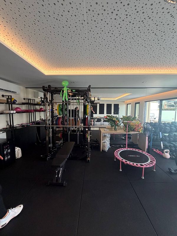 A man working out in a gym, using a smith machine for weight training.