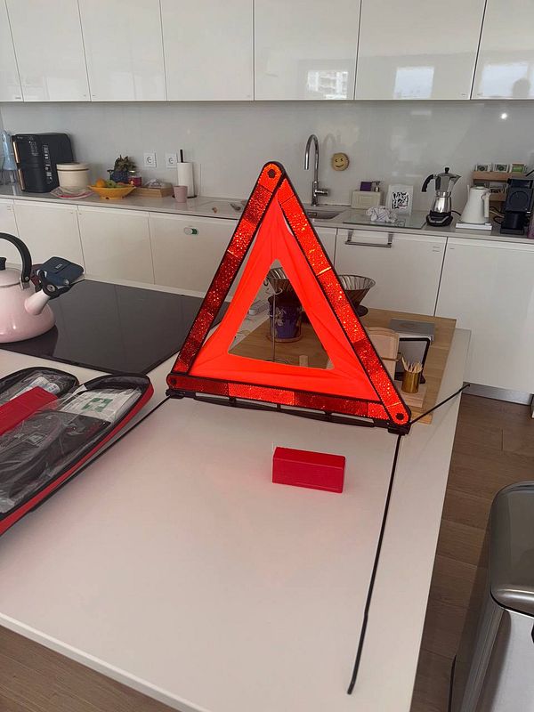 A bright red warning triangle is prominently displayed on a kitchen countertop.