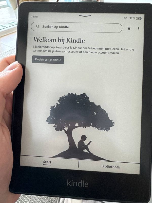 A Kindle e-reader displays a welcome screen prompting registration.