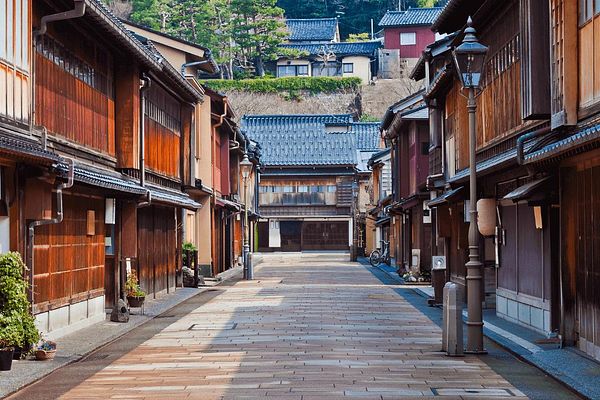 A picturesque street in Kanazawa, Japan, featuring traditional wooden buildings and a serene atmosphere.