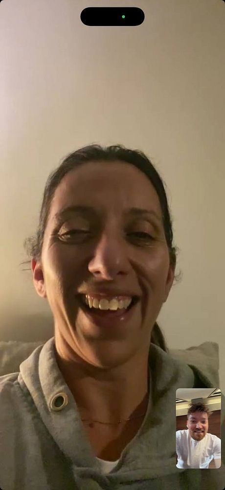 Person lifting dumbbells in a gym setting with gym equipment and workout stations in the background.