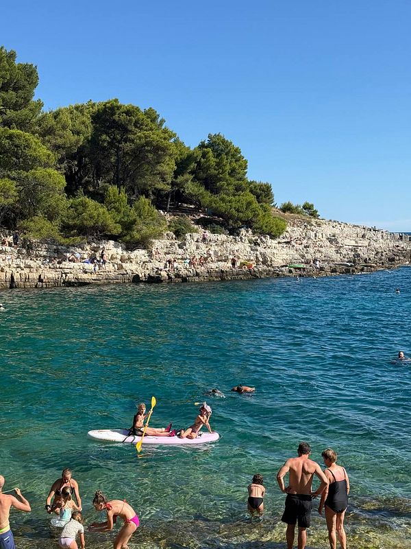 A vibrant beach scene in Croatia featuring people enjoying the water and sun.