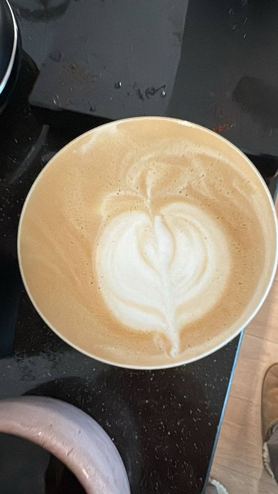 A close-up of a modern espresso machine with a cup placed below the spout.