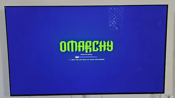 Screen displaying the Omarchy installation progress on a Mini PC.