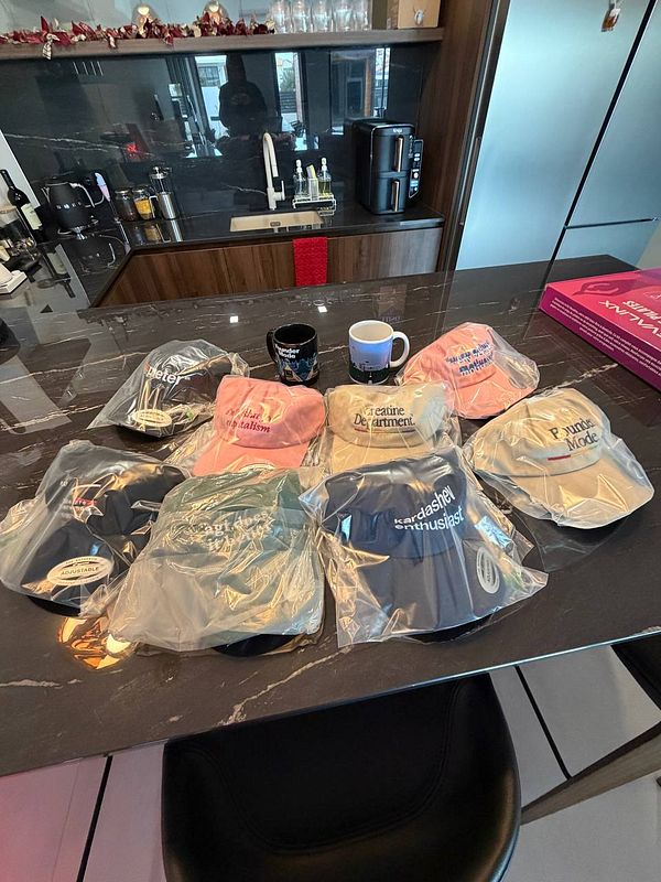 A collection of branded caps and mugs displayed on a kitchen countertop.