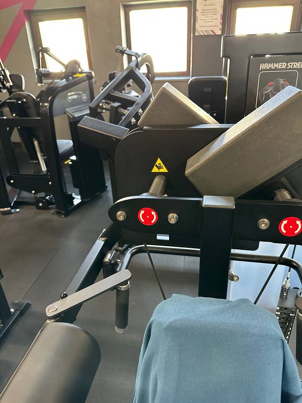 The image captures a gym interior featuring various exercise machines.