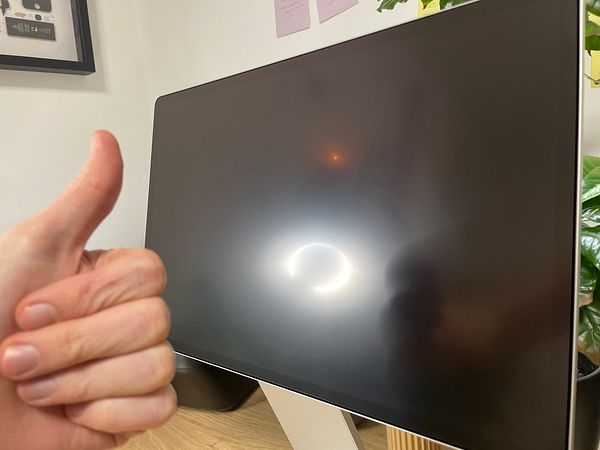 A person gives a thumbs-up next to a matte screen protector applied on a glossy portable monitor.