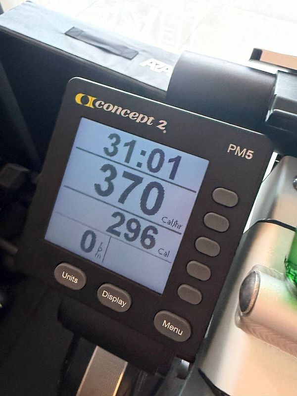 Woman in a gym performing cardio on a treadmill wearing athletic wear and wireless headphones.