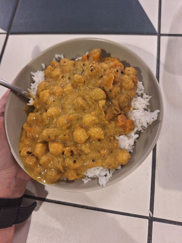 A bowl of coconut turmeric chickpea curry served over rice.
