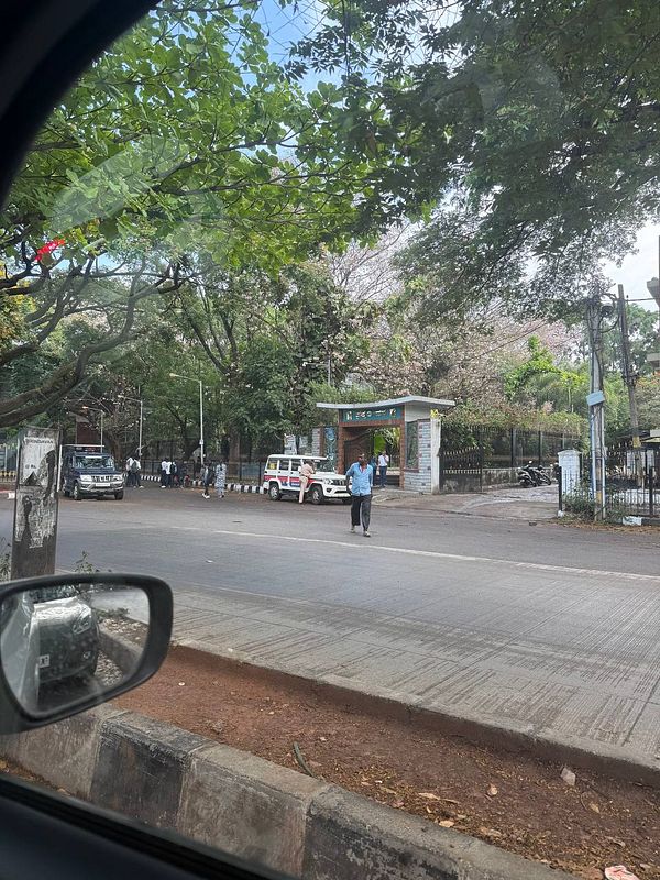 A street view in Bangalore featuring lush greenery and a pedestrian crossing.