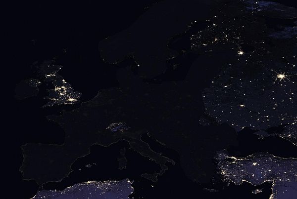 A nighttime satellite view of Europe highlighting urban areas with artificial lighting.