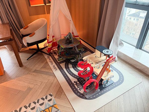 Empty modern hotel room with minimalist furniture and large windows.