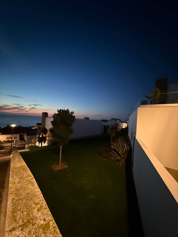A serene evening landscape featuring a garden and a twilight sky.