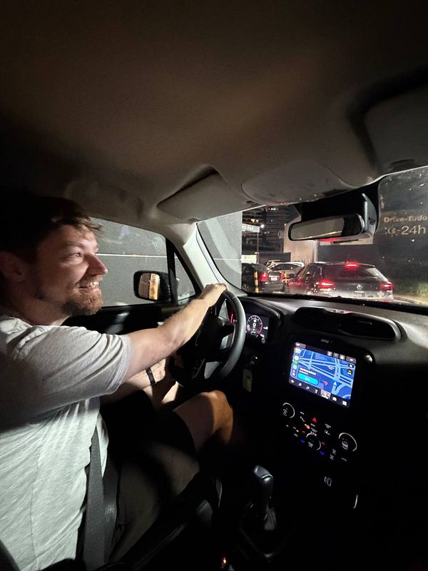 A close-up photo of a woman sitting in a car, smiling, likely at a McDonald's drive-thru.