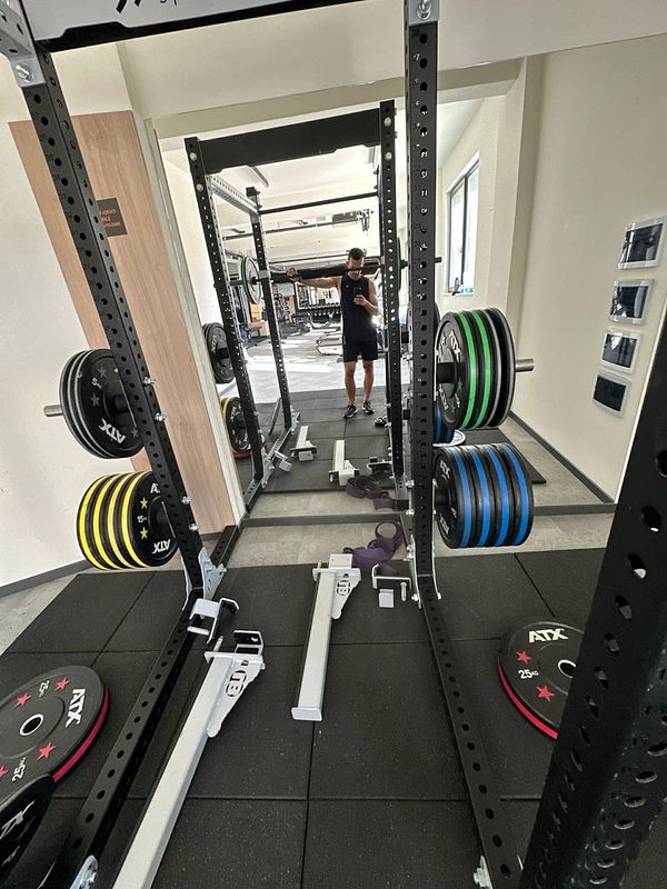 A gym setting featuring a weightlifting rack and various weights.