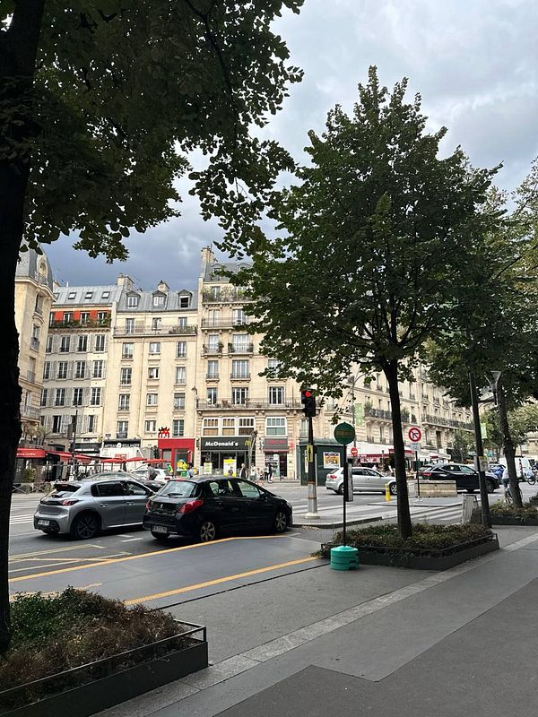 A bustling street scene in Paris featuring historic buildings and modern elements.