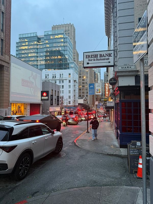 A nighttime street scene in San Francisco featuring emergency responders attending to an incident outside a building.