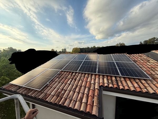 A rooftop installation of solar panels on a tiled roof.