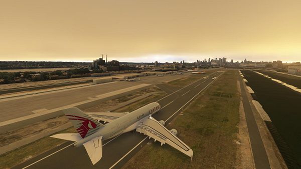 A Qatar Airways airplane is positioned on a runway with a city skyline in the background under a hazy sky.