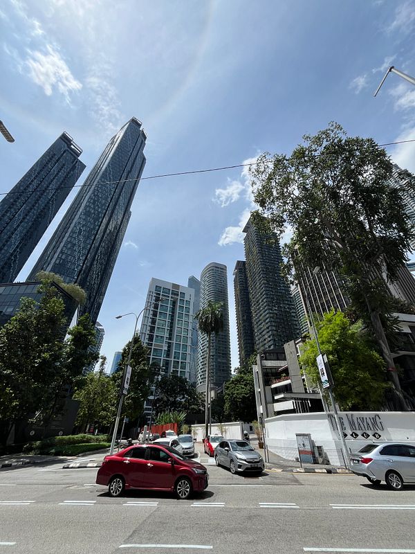 A bustling urban scene in Kuala Lumpur featuring modern skyscrapers and busy streets.