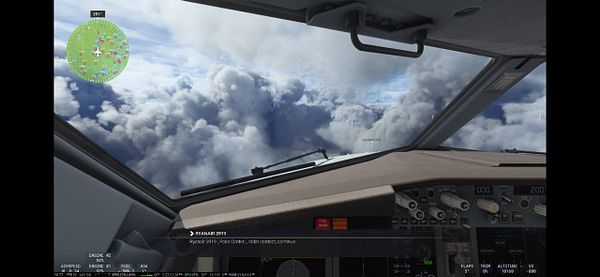 The image captures the cockpit view of an aircraft flying above a cloud layer with a navigation display on the left.