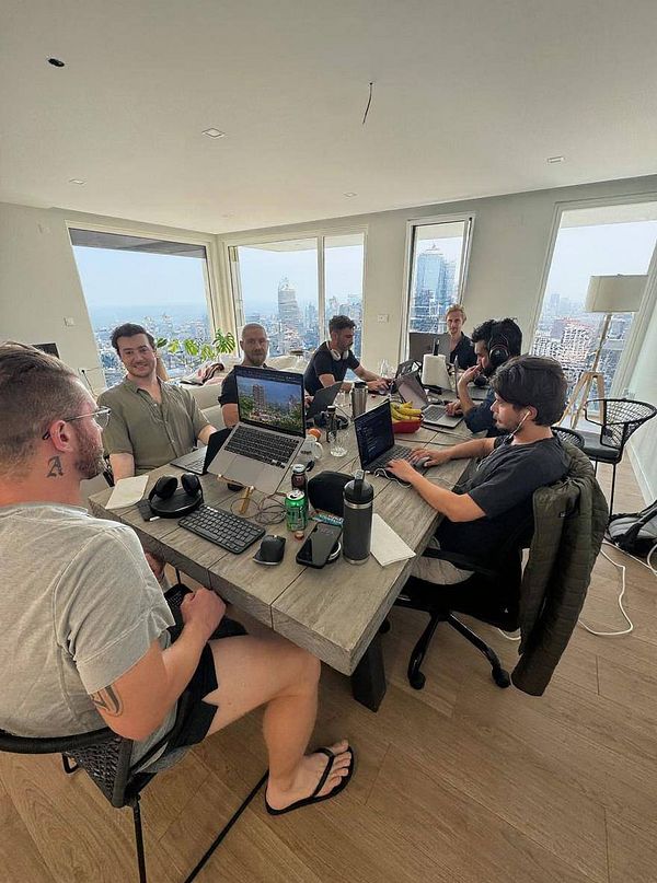 A group of people is collaborating in a modern workspace with a stunning city view.
