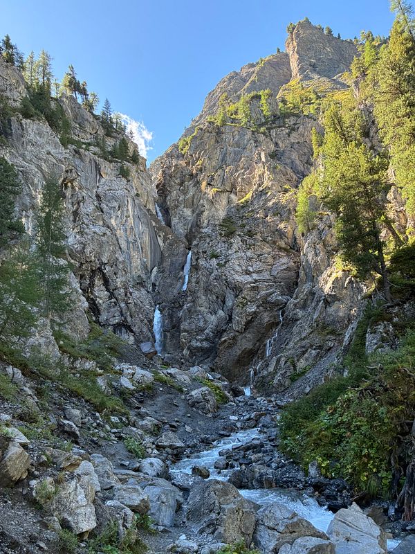 A scenic mountain waterfall surrounded by rocks and greenery near Davos.