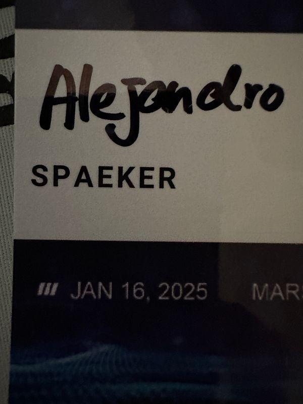 A conference badge with the name 'Alejandro' and the title 'SPAEKER'.