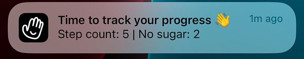 A notification alerting the user to track their progress with step count and sugar intake.