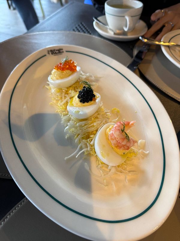 A beautifully presented dish featuring three gourmet appetizers on a white plate.