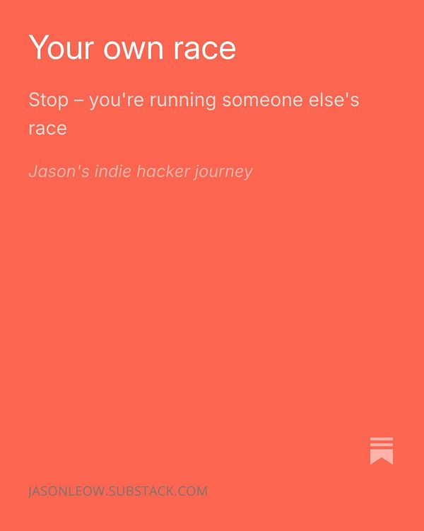 Portrait of a man in a white shirt and black jacket, smiling at the camera against a dark background.