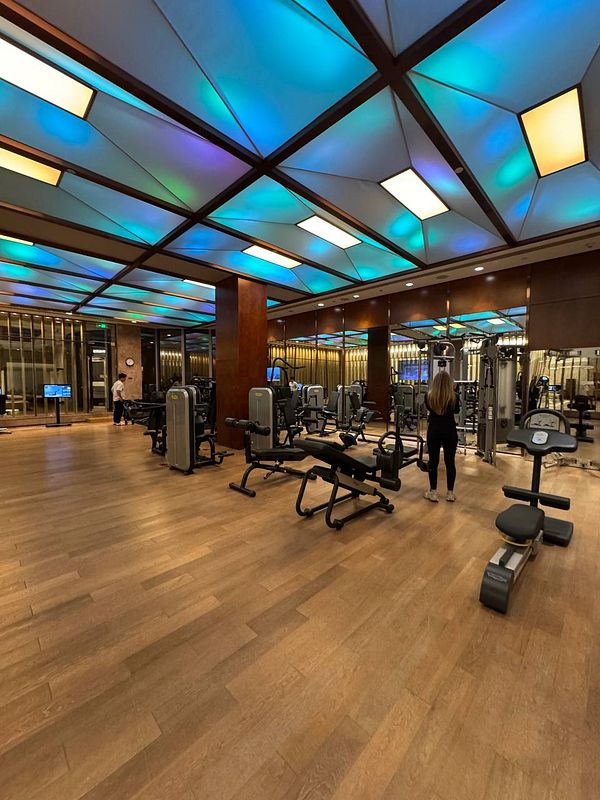 A modern gym interior in Shanghai featuring various workout equipment and ambient lighting.