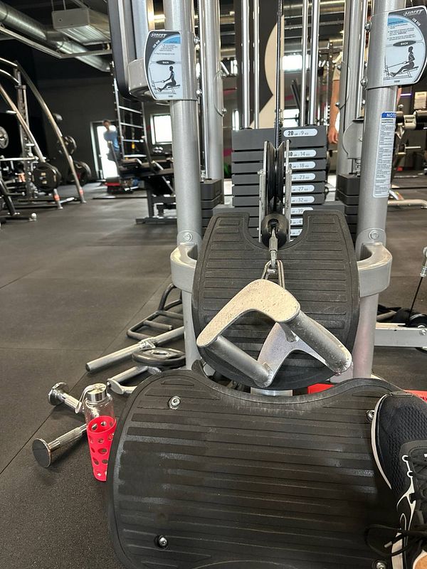 A gym setting featuring a weight machine and various free weights.