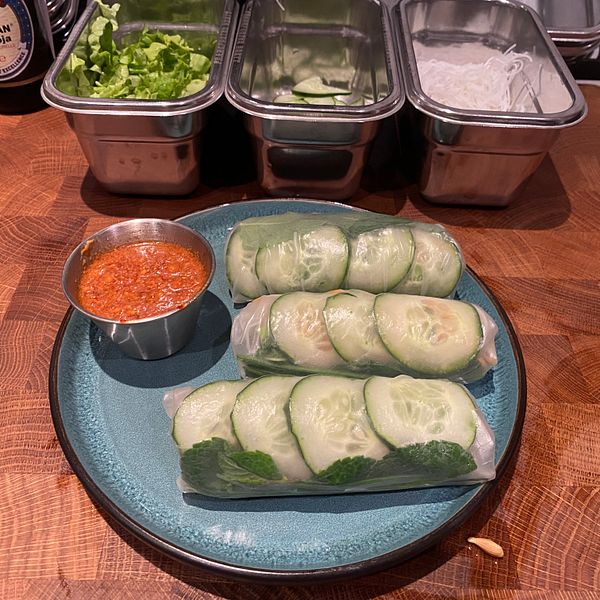A plate of fresh cucumber rolls accompanied by a dipping sauce.