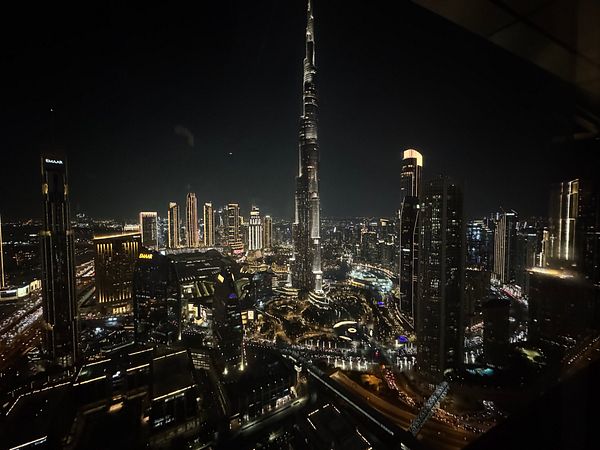 A stunning nighttime view of Dubai's skyline featuring the Burj Khalifa and surrounding illuminated buildings.