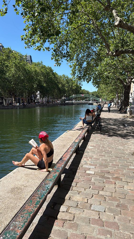 A vibrant photo of a Paris street in summer featuring a cyclist and classic architecture.